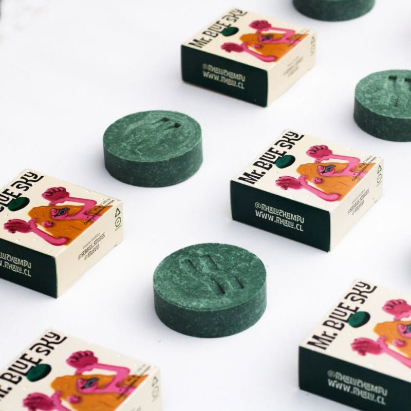 Exhibición de varias unidades del champú sólido Mr. Blue Sky de Khalú con su empaque, dispuestas sobre una superficie blanca, resaltando su presentación y diseño.