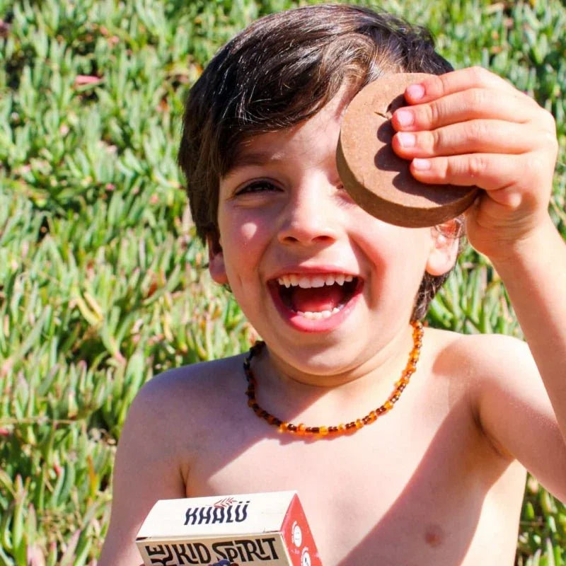 Niño con champú sólido Kids Spirit cuero cabelludo sensible, playa con vegetación marina