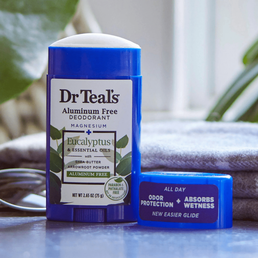 Desodorante Dr Teal’s Eucalyptus & Essential Oils destapado, colocado sobre una superficie junto a su tapa. Producto de origen natural, ideal para el cuidado diario.