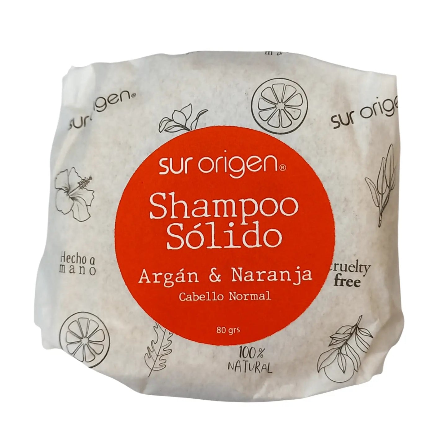 Empaque de shampoo sólido Sur Origen con argán y naranja para cabello normal. Envuelto en papel ecológico con diseño minimalista en tonos beige y rojo. Etiqueta con certificaciones hecho a mano, cruelty free y 100% natural. Peso de 80 gramos.