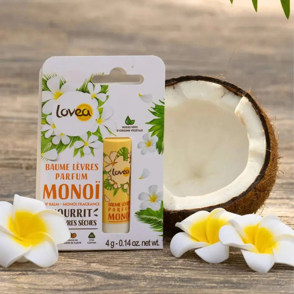 Bálsamo labial Lovea Monoï de 4g con fragancia tropical, enriquecido con manteca de karité y aceites 100% vegetales. Presentado junto a coco partido y flores de tiaré, ideal para labios secos. Envase reciclable, fabricado en Francia.