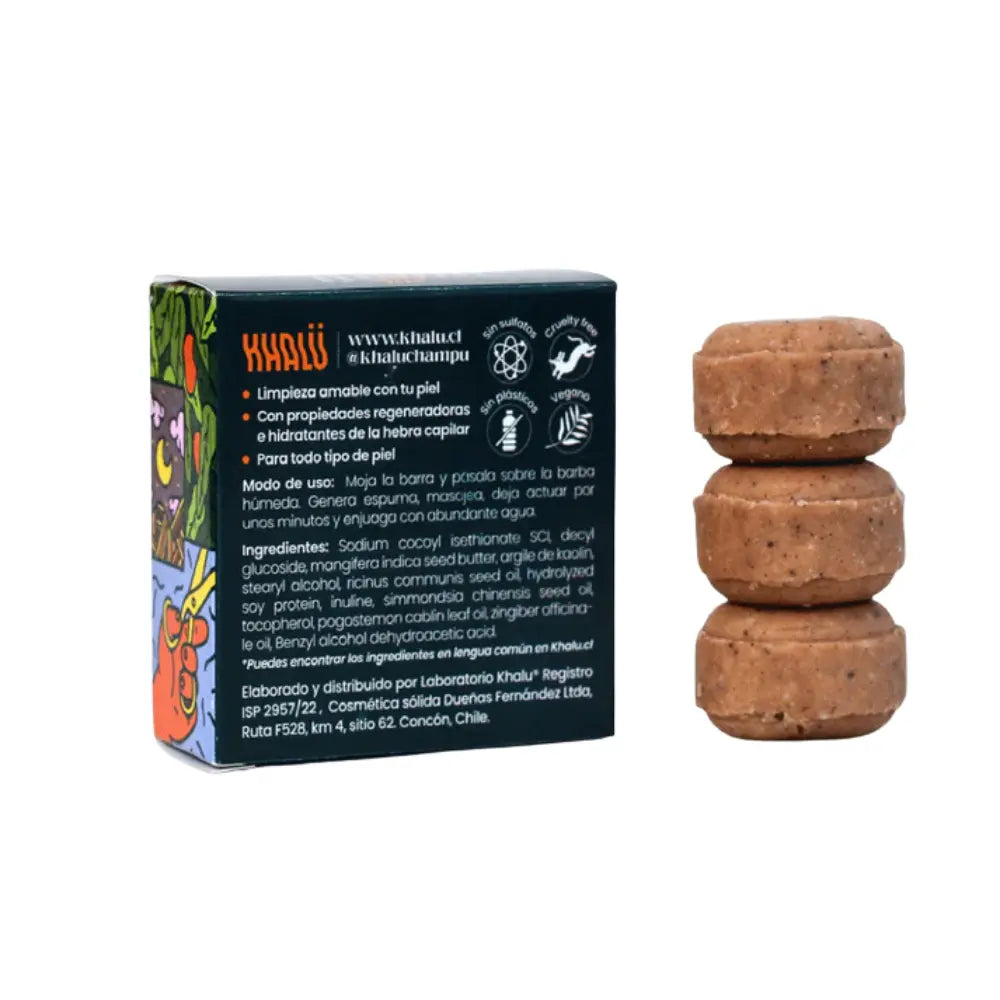 Vista posterior del empaque del champú sólido “barba bloom” junto a tres pastillas apiladas del producto. La caja muestra información sobre sus propiedades: limpieza amable, regeneración e hidratación capilar, y apto para todo tipo de piel. También se indican el modo de uso, ingredientes como manteca de mango, aceites esenciales y fitoqueratina, así como íconos que representan que es libre de sulfatos, cruelty-free, vegano y sin plásticos. La marca Khalü y su sitio web también son visibles.