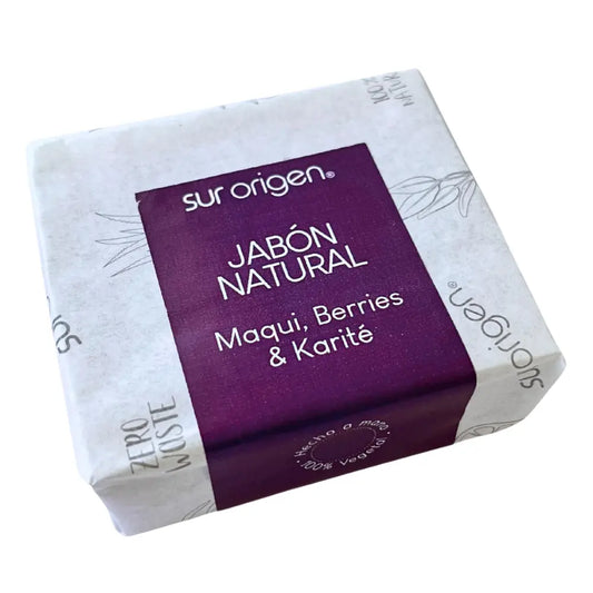 Jabón natural Sur Origen con envoltorio blanco decorado y etiqueta morada que indica su fórmula con Maqui, Berries y Karité. Producto vegano, artesanal y con enfoque ecológico, ideal para el cuidado de la piel.