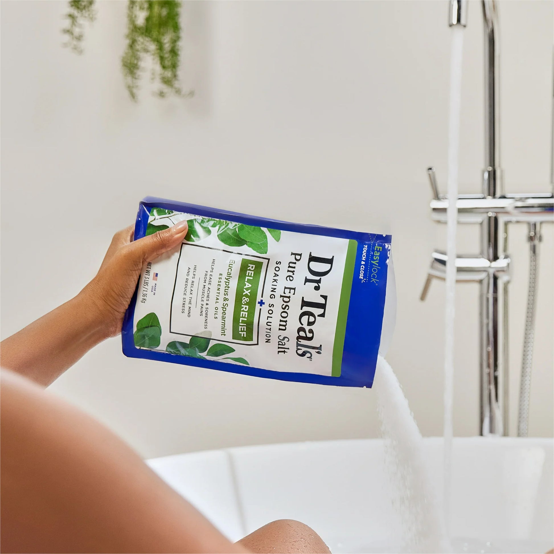 Persona vertiendo Dr Teal’s Pure Epsom Salt Soaking Solution en una bañera, resaltando su uso para el bienestar y la relajación.