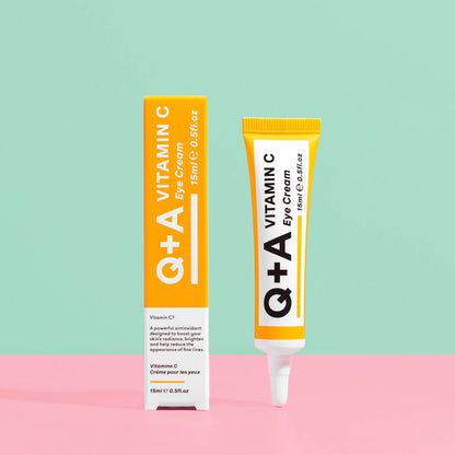 Crema para ojos con vitamina C de Q+A en su presentación de tubo y caja, con fondo en colores pastel. Diseño limpio y moderno en tonos naranja y blanco. Indicación de antioxidantes y reducción de líneas finas.