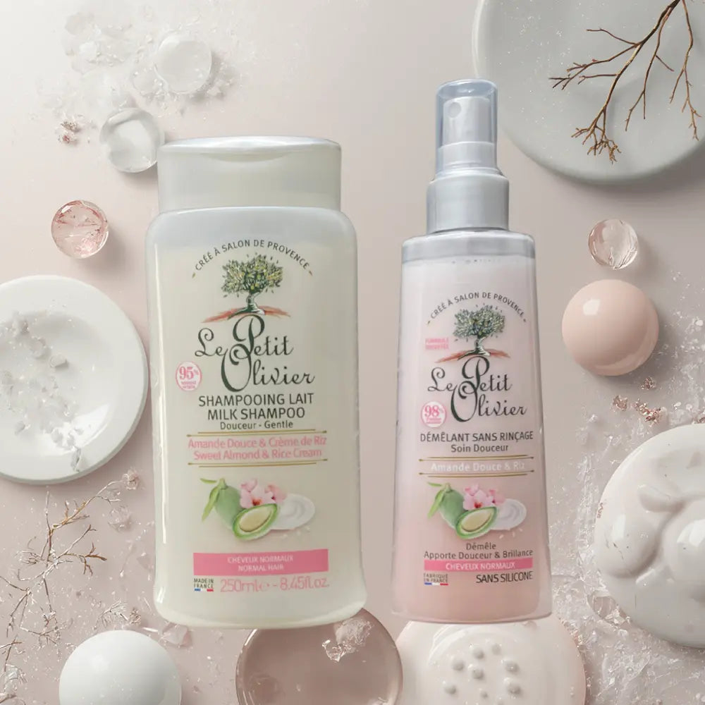Set Le Petit Olivier con shampoo y desenredante de almendra dulce y crema de arroz sobre fondo rosa con elementos spa