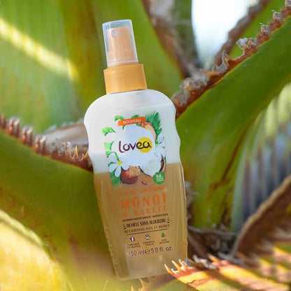 Foto del spray desenredante Lovea Monoi & Karité de 150 ml apoyado sobre hoja de aloe, ideal para cabello seco