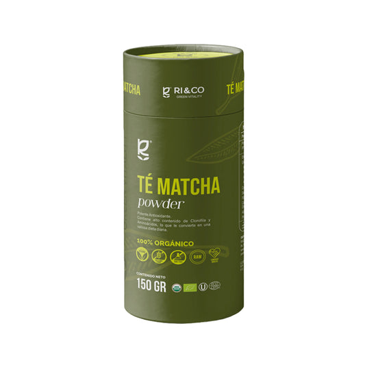 Envase cilíndrico verde de Té Matcha en polvo de la marca RI & CO Green Vitality. El empaque resalta que es 100% orgánico, con certificaciones visibles y propiedades como alto contenido en clorofila y aminoácidos. Contenido neto: 150 gramos. Íconos indican que es vegano, sin gluten, sin azúcar añadida y producto RAW.